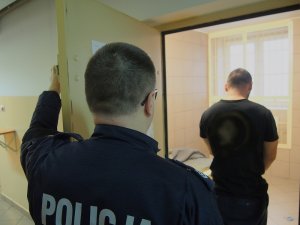 Policjant podczas czynności z podejrzanym o dewastacje