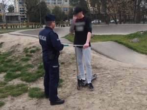 Policjant wyjaśnia 20-latkowi komunikat Prezydenta Miasta Otwocka