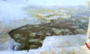 Na zdjęciu widać pęknięty lód na zbiorniku wodnym.