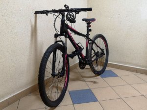 Na zdjęciu jest rower typu górskiego koloru czarno-różowego.