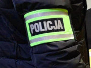 Na zdjęciu widać założoną na przedramię opaskę odblaskową z napisem policja.