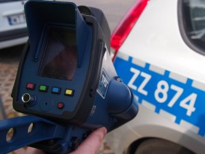 Na zdjęciu widać urządzenie do pomiaru prędkości, które trzyma policjant.