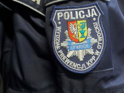 Na zdjęciu widać rękaw policyjnej kurtki z logiem policji.