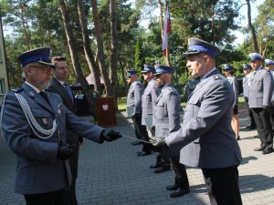 Na zdjęciu widać jak Komendant Powiatowy Policji w Otwocku młodszy inspektor Przemysław Dębiński przekazuje akt mianowania policjantowi, który stoi w szeregu.