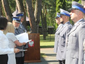 Na zdjęciu widać jak Komendant Powiatowy Policji w Otwocku młodszy inspektor Przemysław Dębiński wręcza akt mianowania policjantowi, który stoi w szeregu.