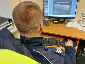 Na zdjęciu widać umundurowanego policjanta z drogówki - sierż. szt. Marcina Jabłońskiego, w trakcie szkolenia on-line.