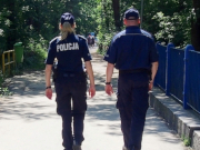 Na zdjęciu widać umundurowany patrol policji w trakcie pieszego patrolu. Osoby są odwrócone tyłem do zdjęcia.