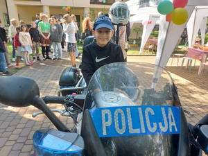 Chłopiec siedzący na policyjnym motocyklu.