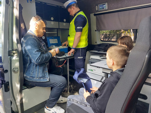 umundurowany policjant przeprowadzający pokazową kontrolę stanu trzeźwości.