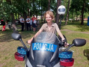 Dziewczynka siedząca na policyjnym motocyklu.